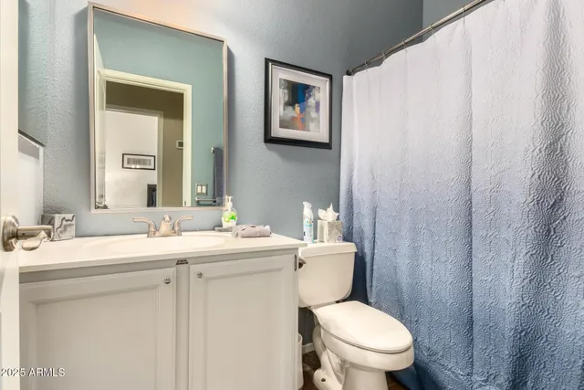 a bathroom with a toilet a sink and mirror