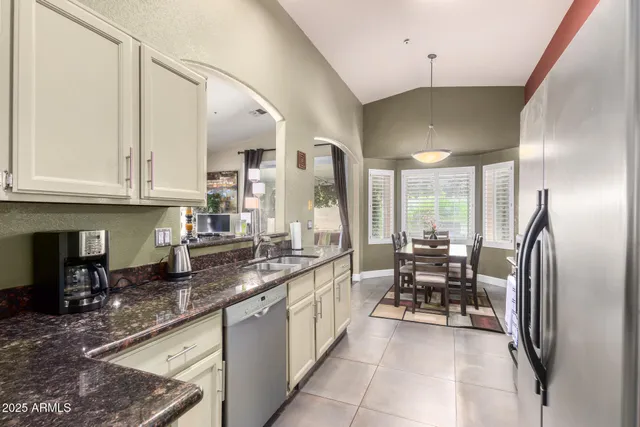 a kitchen with stainless steel appliances granite countertop a sink a stove and a refrigerator