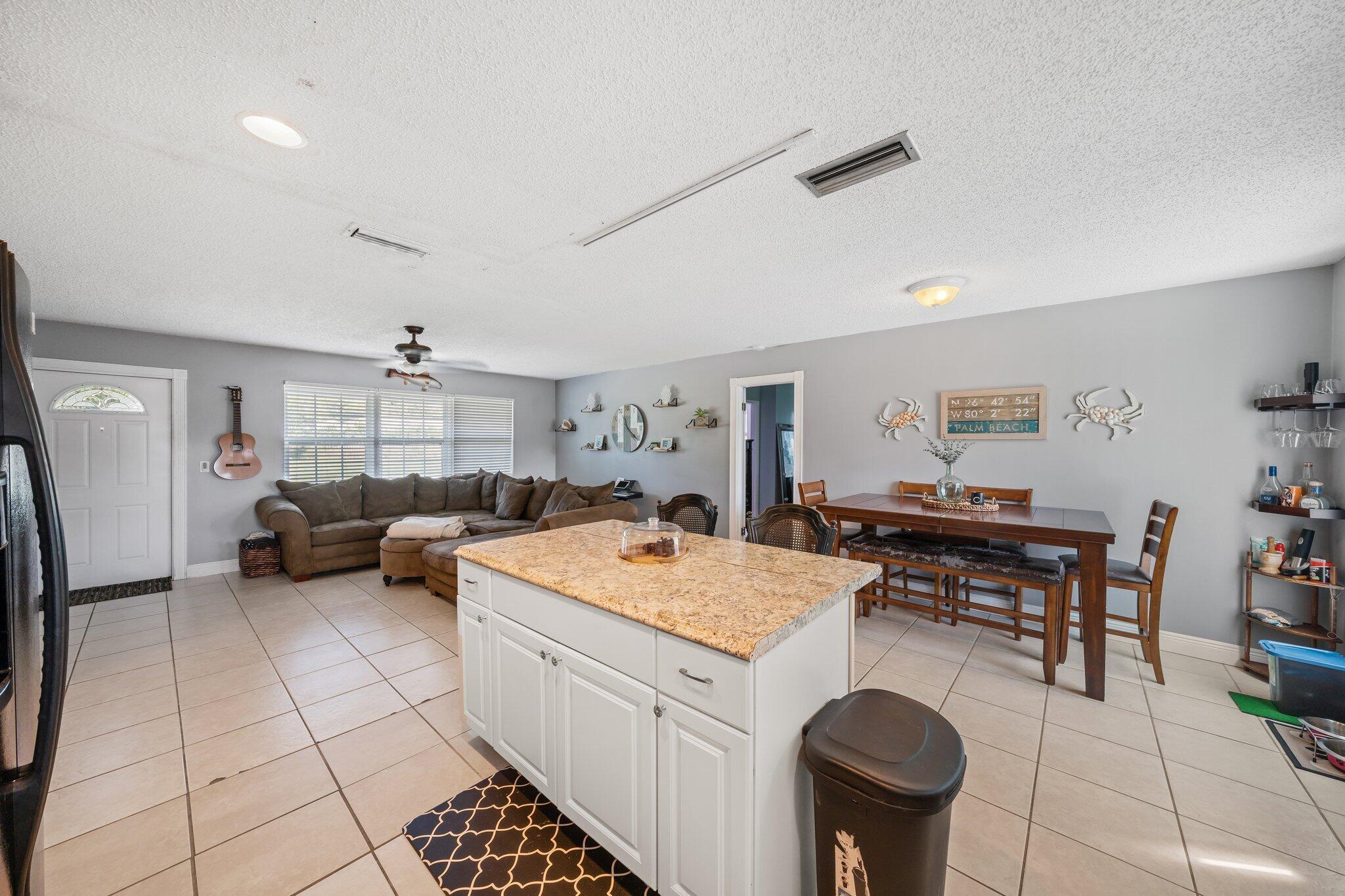 5810 Tucker Road Jupiter, FL 33458 - Photo 11 of 51 a large white kitchen with a stove a sink dishwasher and cabinets with wooden floor