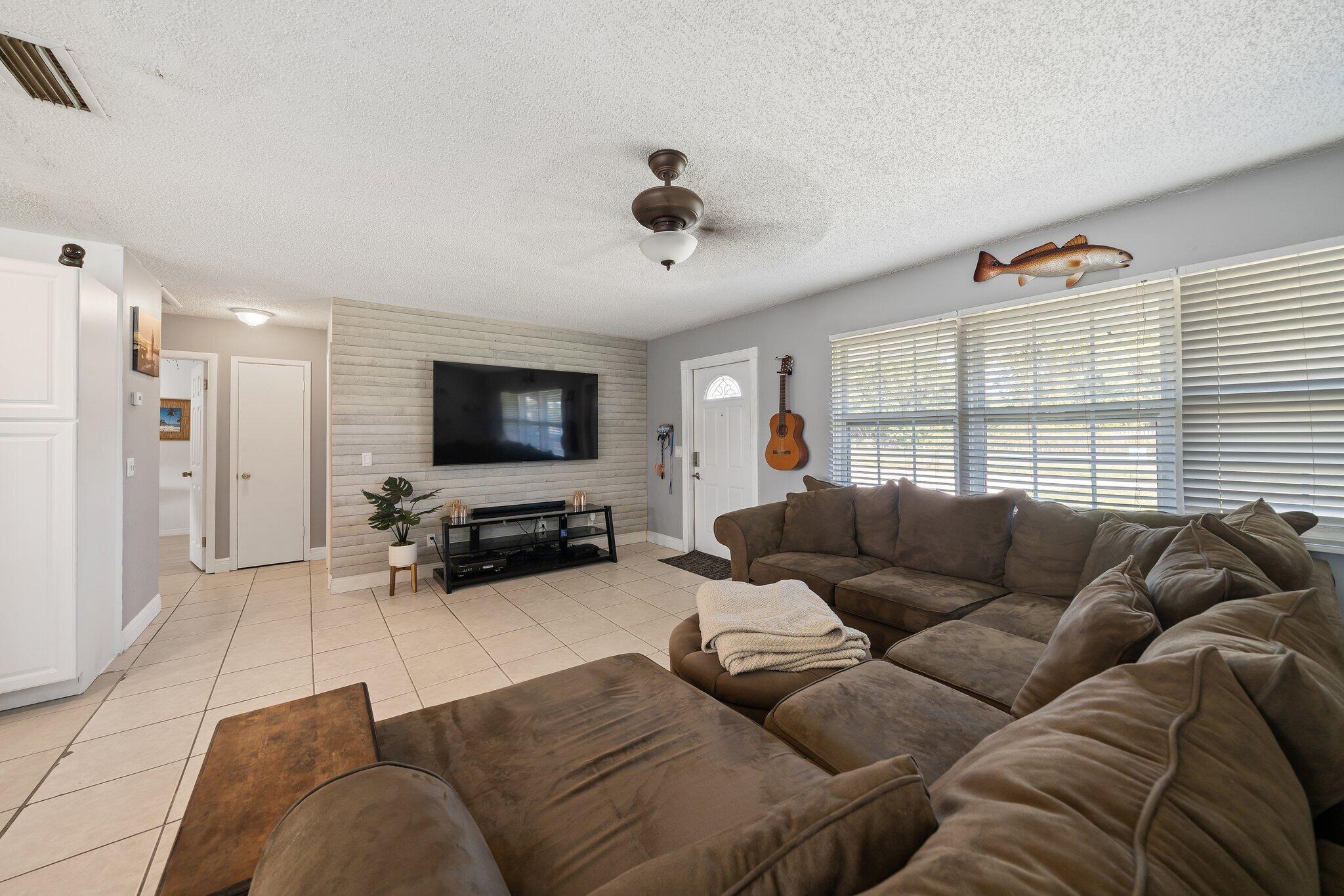 5810 Tucker Road Jupiter, FL 33458 - Photo 12 of 51 a living room with furniture window and a flat screen tv