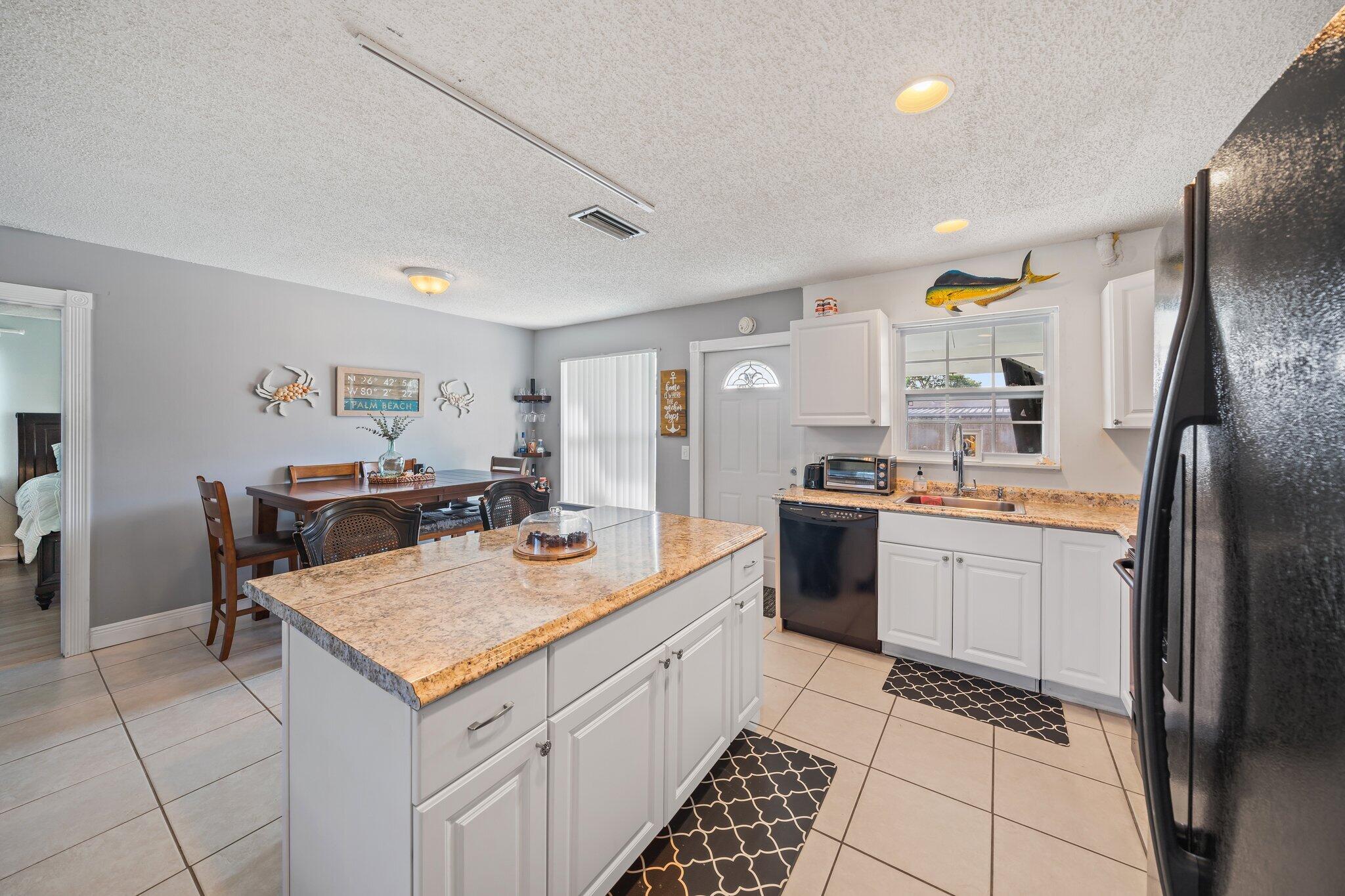 5810 Tucker Road Jupiter, FL 33458 - Photo 14 of 51 a kitchen with a refrigerator a sink and cabinets