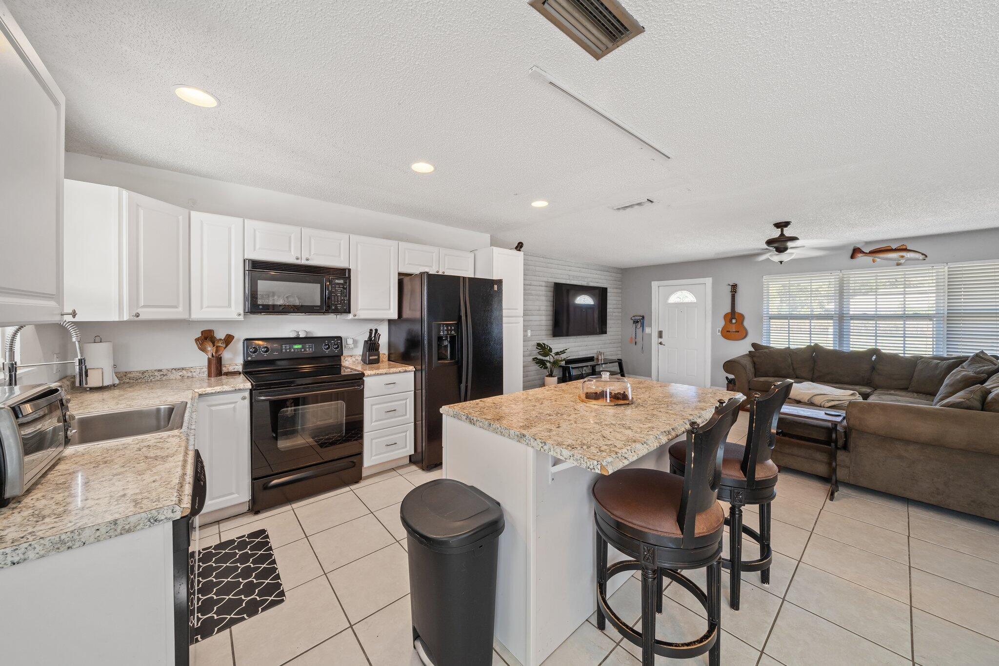 5810 Tucker Road Jupiter, FL 33458 - Photo 5 of 51 a large kitchen with a table chairs refrigerator and cabinets