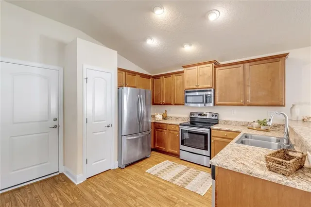 a kitchen with stainless steel appliances granite countertop a refrigerator stove and sink