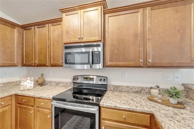 a kitchen with granite countertop cabinets stainless steel appliances and a counter space