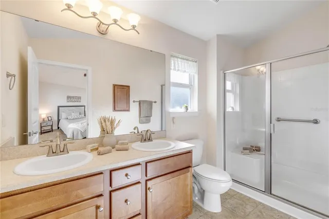 a bathroom with a double vanity sink mirror and toilet
