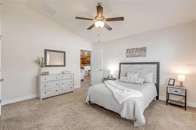 a bedroom with a bed a chandelier and a dresser