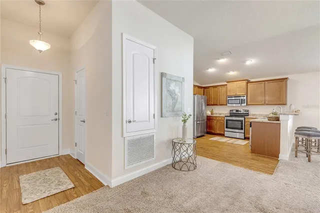 a view of kitchen with kitchen island wooden cabinets and refrigerator