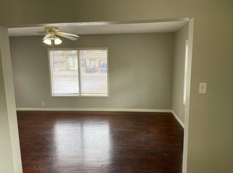 2607 27th Street Lubbock, TX 79410 - Photo 2 of 13 a view of an empty room with wooden floor and a window