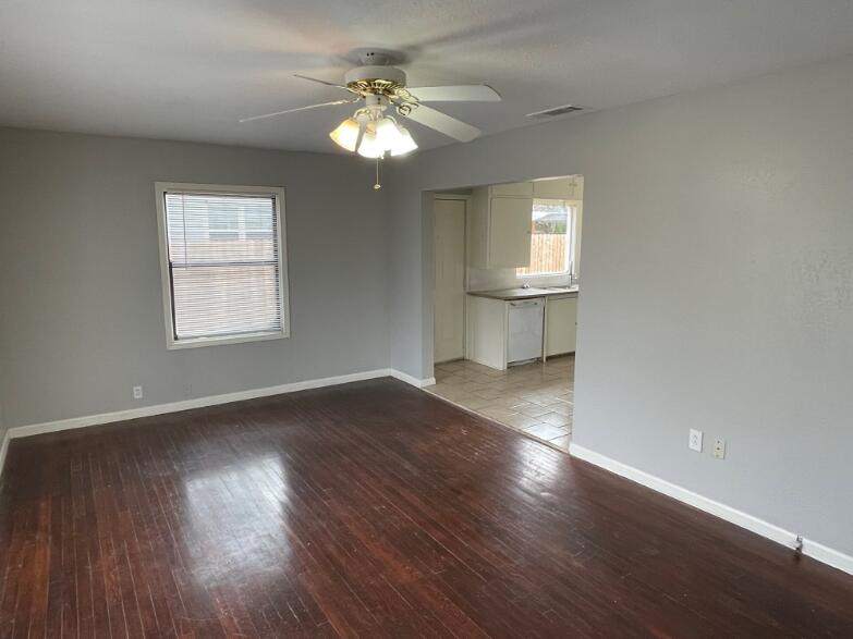 2607 27th Street Lubbock, TX 79410 - Photo 4 of 13 a view of an empty room with wooden floor and a window