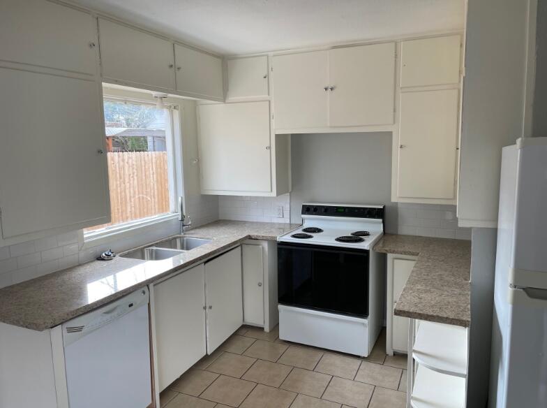 2607 27th Street Lubbock, TX 79410 - Photo 5 of 13 a kitchen with stainless steel appliances a stove a sink and a refrigerator