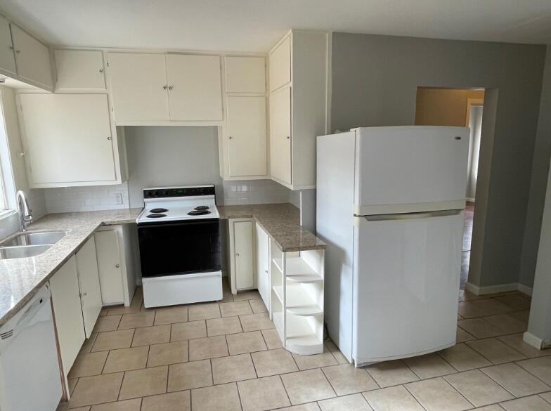 2607 27th Street Lubbock, TX 79410 - Photo 6 of 13 a kitchen with a refrigerator sink stove and cabinets