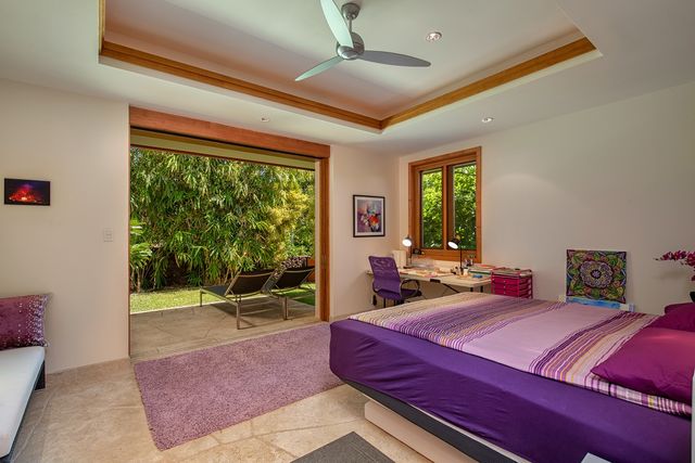 a bedroom with a bed and large windows