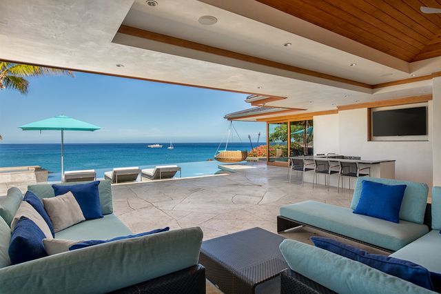 a living room with furniture a flat screen tv and a chandelier