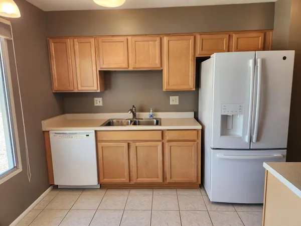 a kitchen with a refrigerator sink and cabinets