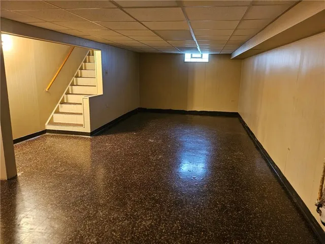 a view of an empty room with wooden floor and stairs