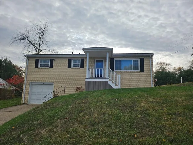a front view of house with yard and green space