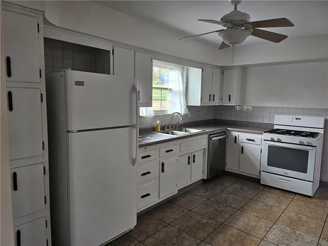 a kitchen with granite countertop white cabinets and white appliances