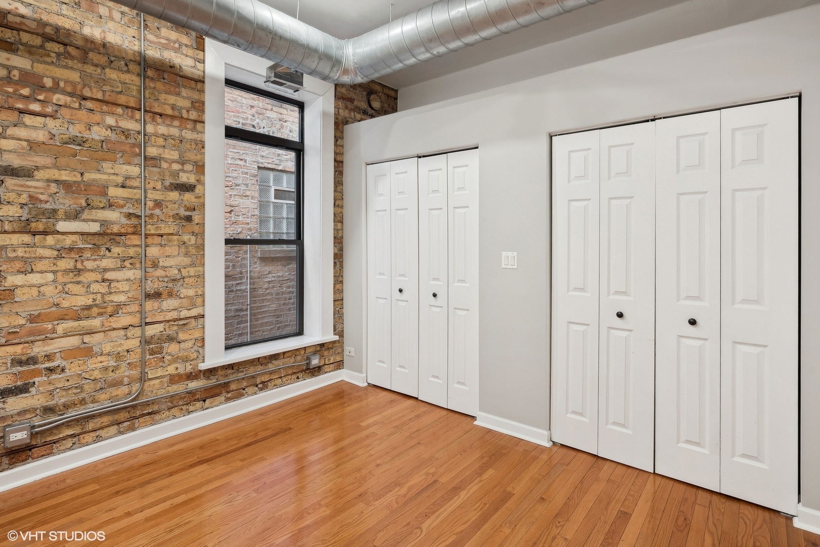 717 West Briar Place, Unit 2W Chicago, IL 60657 - Photo 16 of 26 a view of an empty room with wooden floor and a window