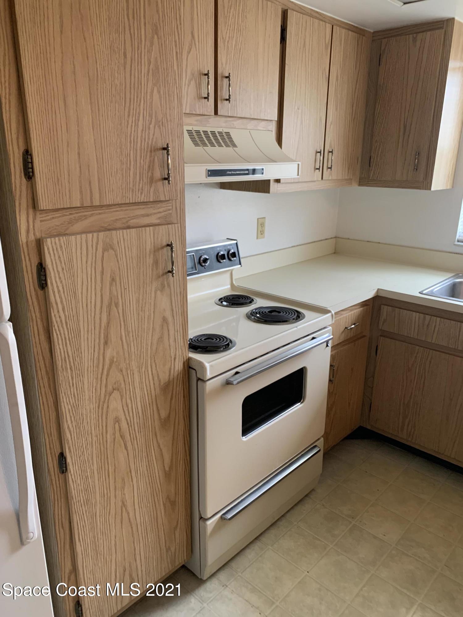 584 North Wickham Road, Unit 86 Melbourne, FL 32935 - Photo 2 of 12 a kitchen with granite countertop white cabinets and white appliances