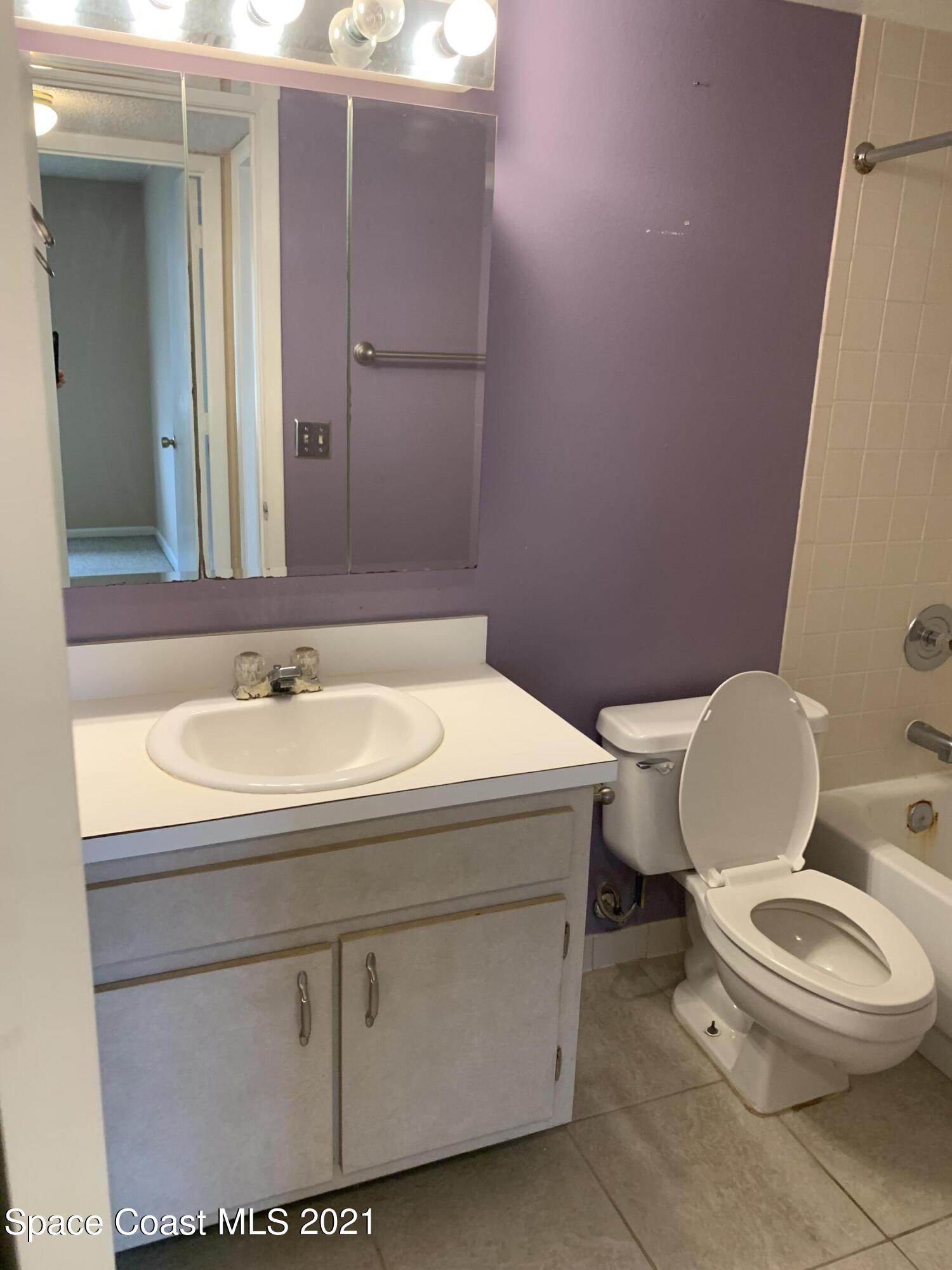 584 North Wickham Road, Unit 86 Melbourne, FL 32935 - Photo 12 of 12 a bathroom with a sink a toilet a mirror and vanity