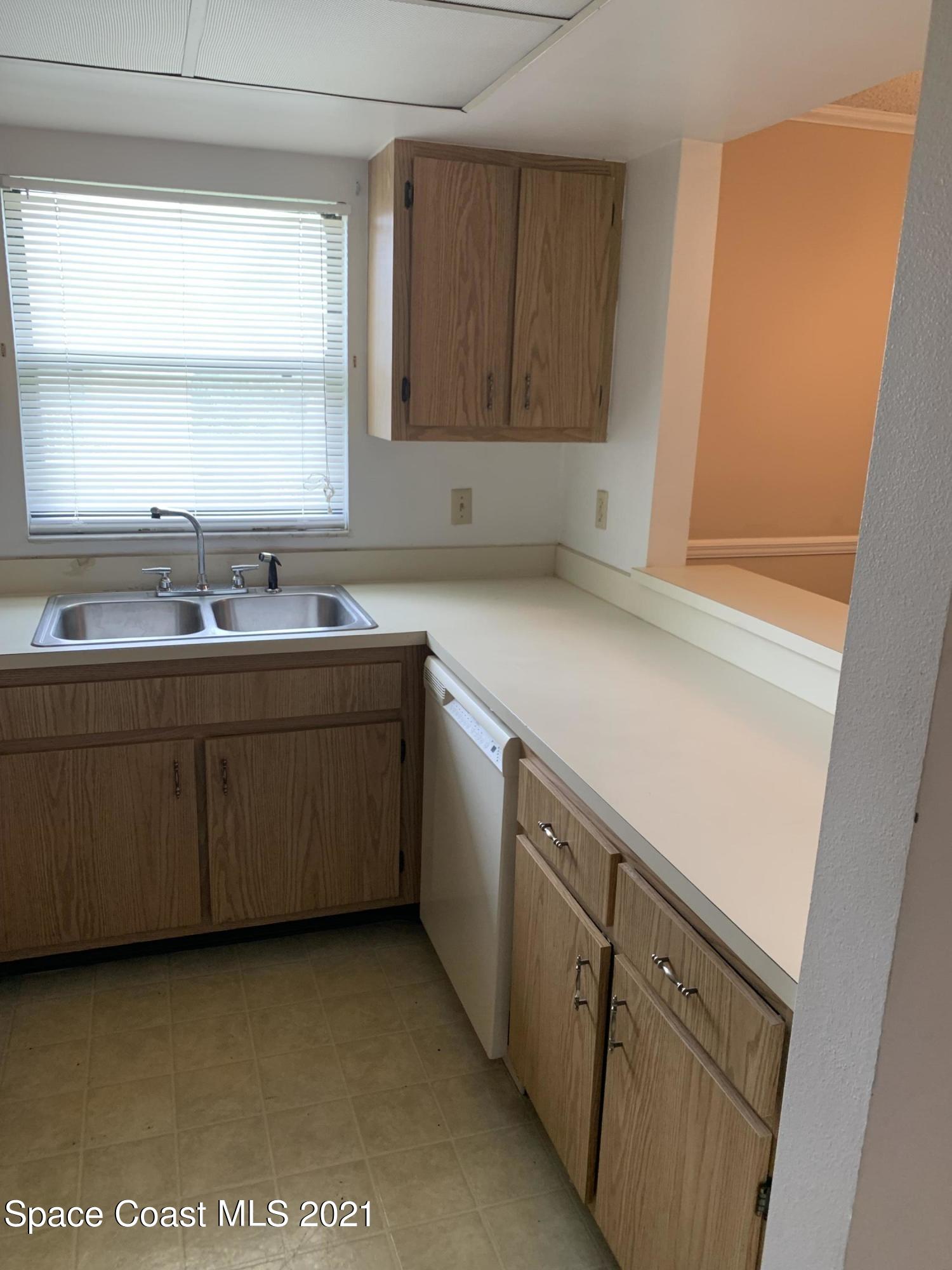 584 North Wickham Road, Unit 86 Melbourne, FL 32935 - Photo 3 of 12 a kitchen with a sink cabinets and window