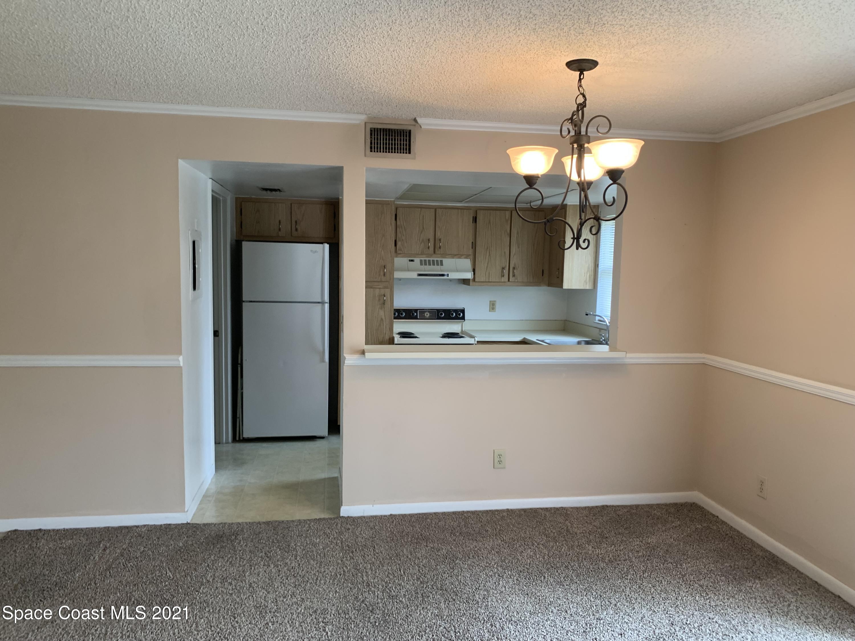 584 North Wickham Road, Unit 86 Melbourne, FL 32935 - Photo 7 of 12 a view of kitchen with refrigerator and microwave