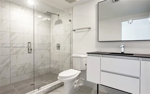 a kitchen with stainless steel appliances a sink a stove a microwave a refrigerator a counter space and cabinets