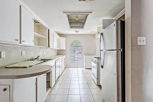 a kitchen with stainless steel appliances granite countertop a refrigerator a stove and a sink