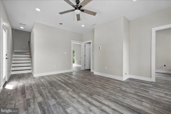 a view of a big room with wooden floor and windows