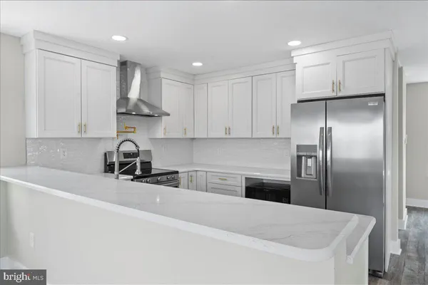 a kitchen with stainless steel appliances granite countertop a sink and a refrigerator