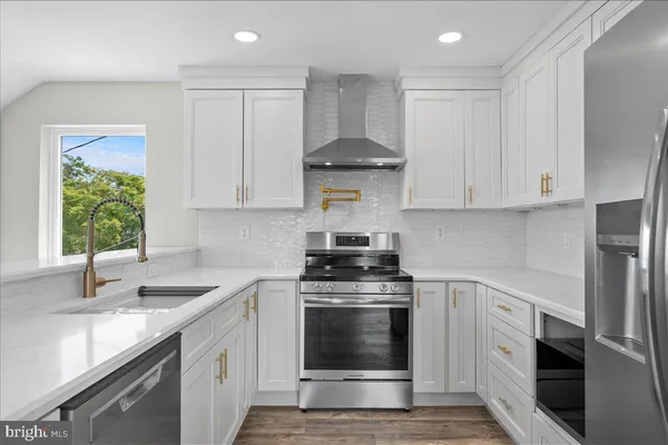 a kitchen with stainless steel appliances granite countertop a sink and a stove