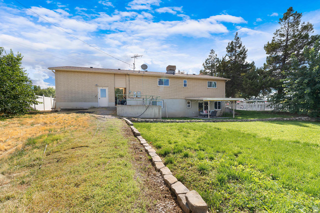 88 West 700 South Payson, UT 84651 - Photo 21 of 27 Rear view of property with a fenced backyard, brick siding, and a patio
