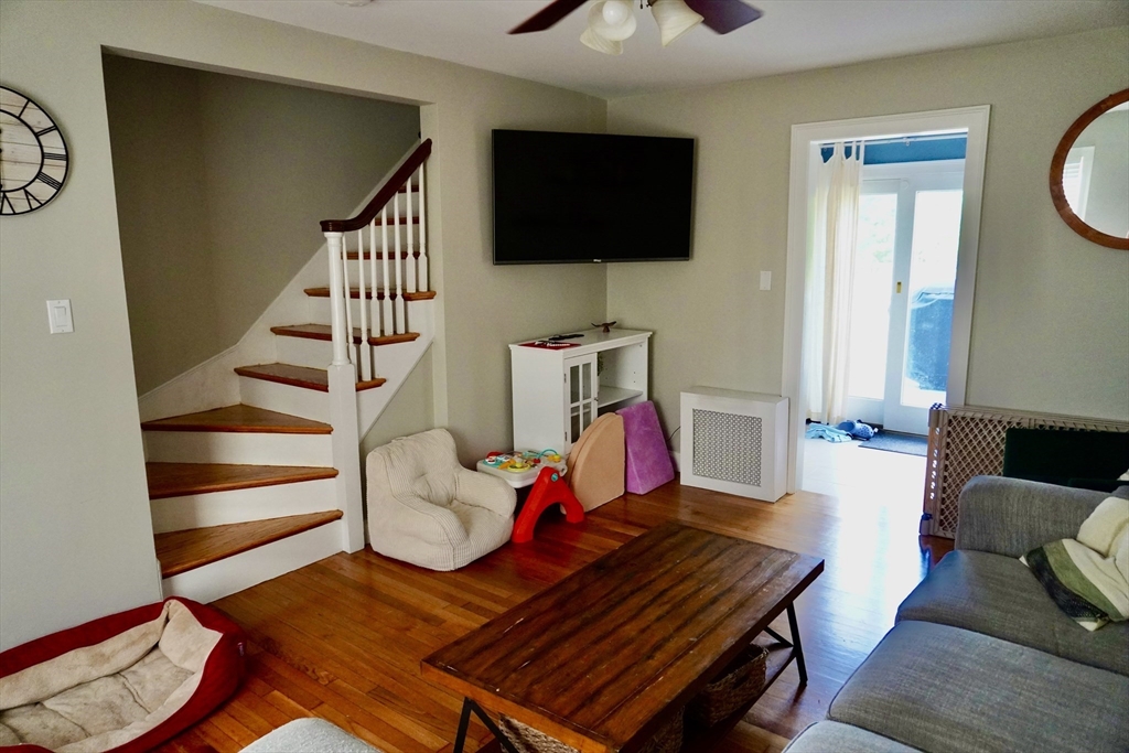 29 Pilgrim Road Weymouth, MA 02191 - Photo 18 of 38 a living room with furniture a flat screen tv and kitchen view