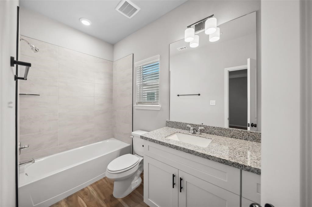 800 North Thompson Street Conroe, TX 77301 - Photo 19 of 25 a bathroom with a granite countertop sink toilet and shower
