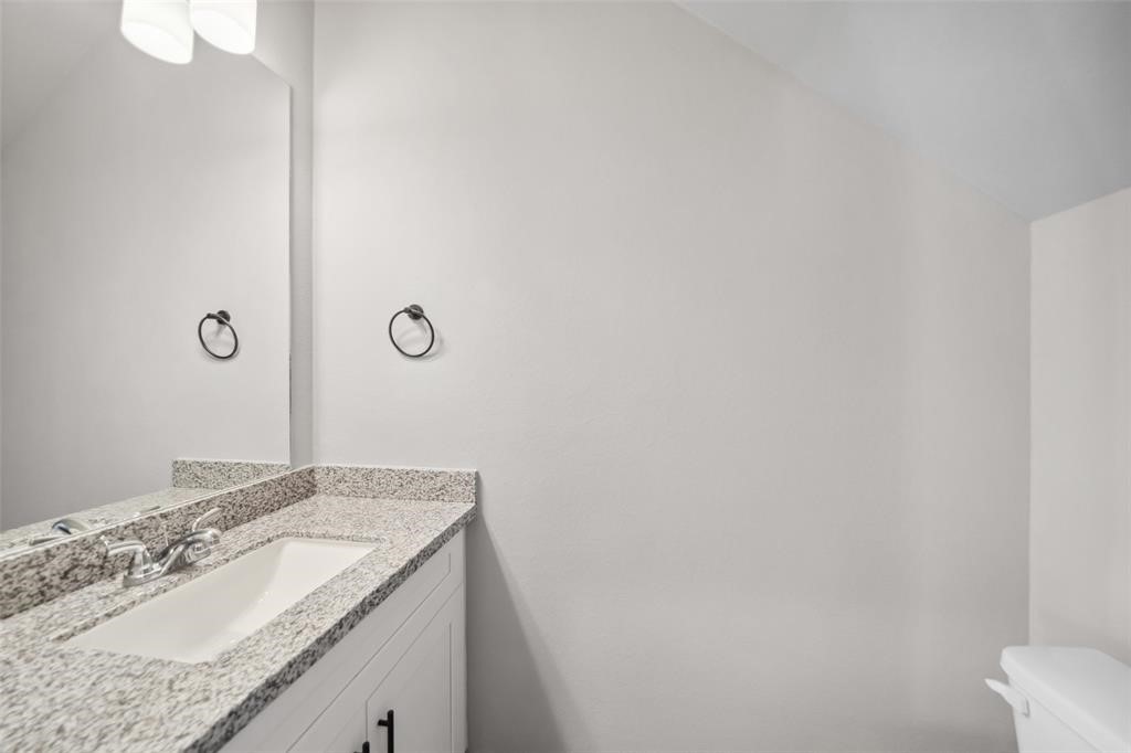 800 North Thompson Street Conroe, TX 77301 - Photo 4 of 25 a bathroom with a granite countertop sink and mirror