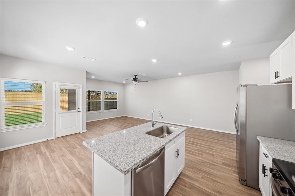 800 North Thompson Street Conroe, TX 77301 - Photo 8 of 25 a kitchen with a sink and a refrigerator