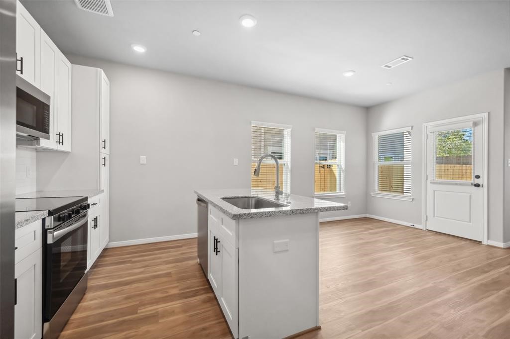 800 North Thompson Street Conroe, TX 77301 - Photo 9 of 25 a kitchen with granite countertop a stove and a sink
