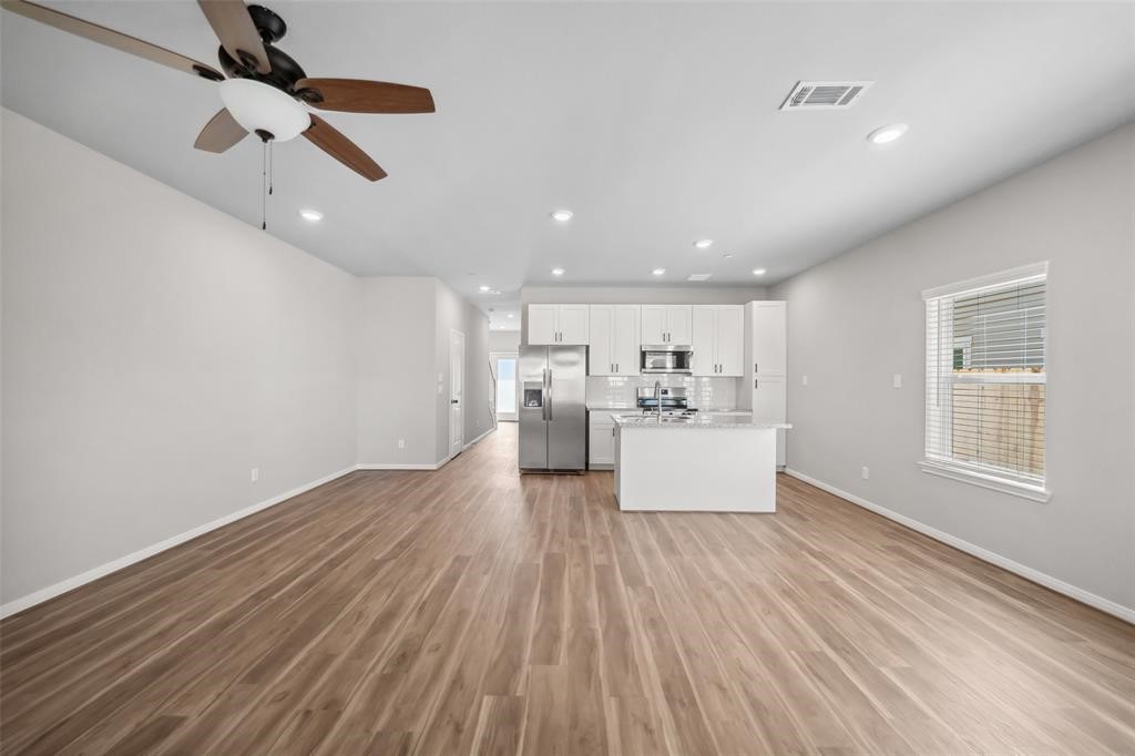 800 North Thompson Street Conroe, TX 77301 - Photo 10 of 25 a view of kitchen and hall with wooden floor
