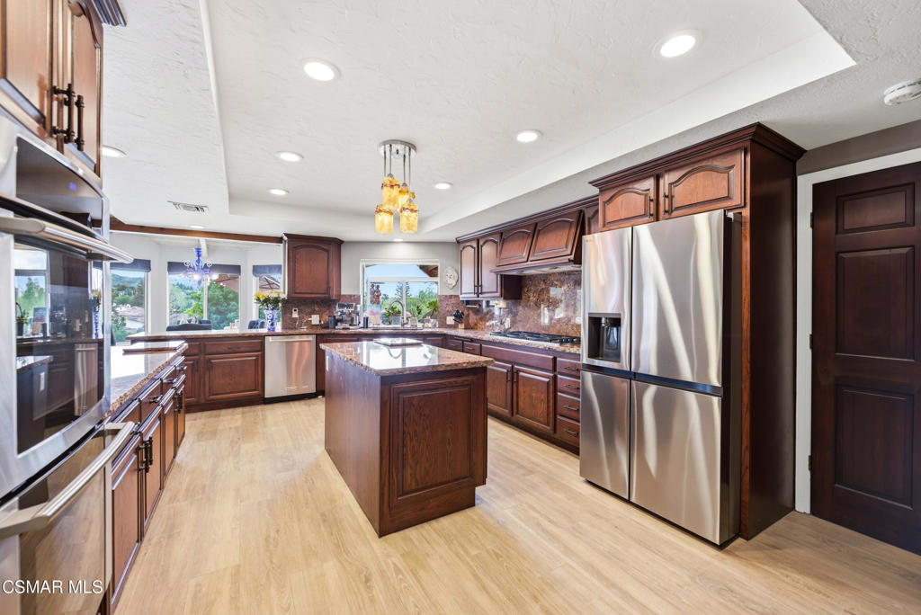 206 Rangely Court Simi Valley, CA 93065 - Photo 12 of 63 a kitchen with stainless steel appliances granite countertop a refrigerator a stove and a wooden floors