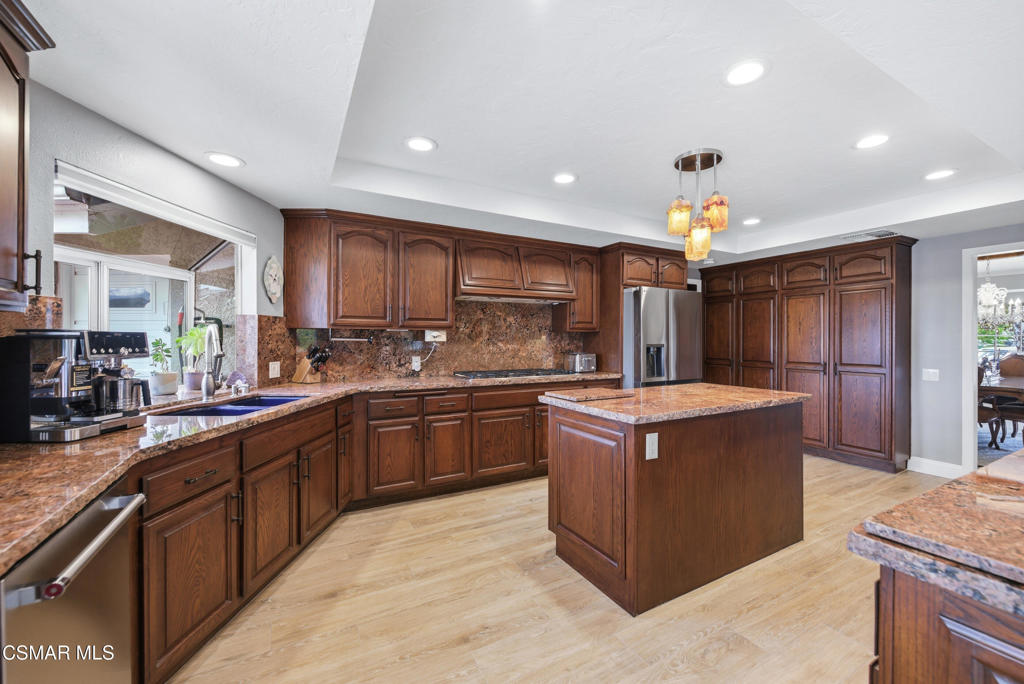 206 Rangely Court Simi Valley, CA 93065 - Photo 13 of 63 a kitchen with stainless steel appliances granite countertop wooden cabinets a sink a stove a washer and dryer