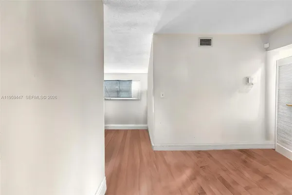 a view of empty room with wooden floor