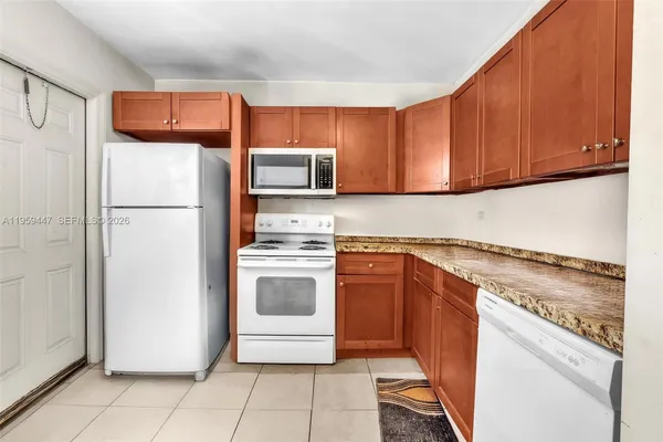 a kitchen with granite countertop a refrigerator and a stove top oven