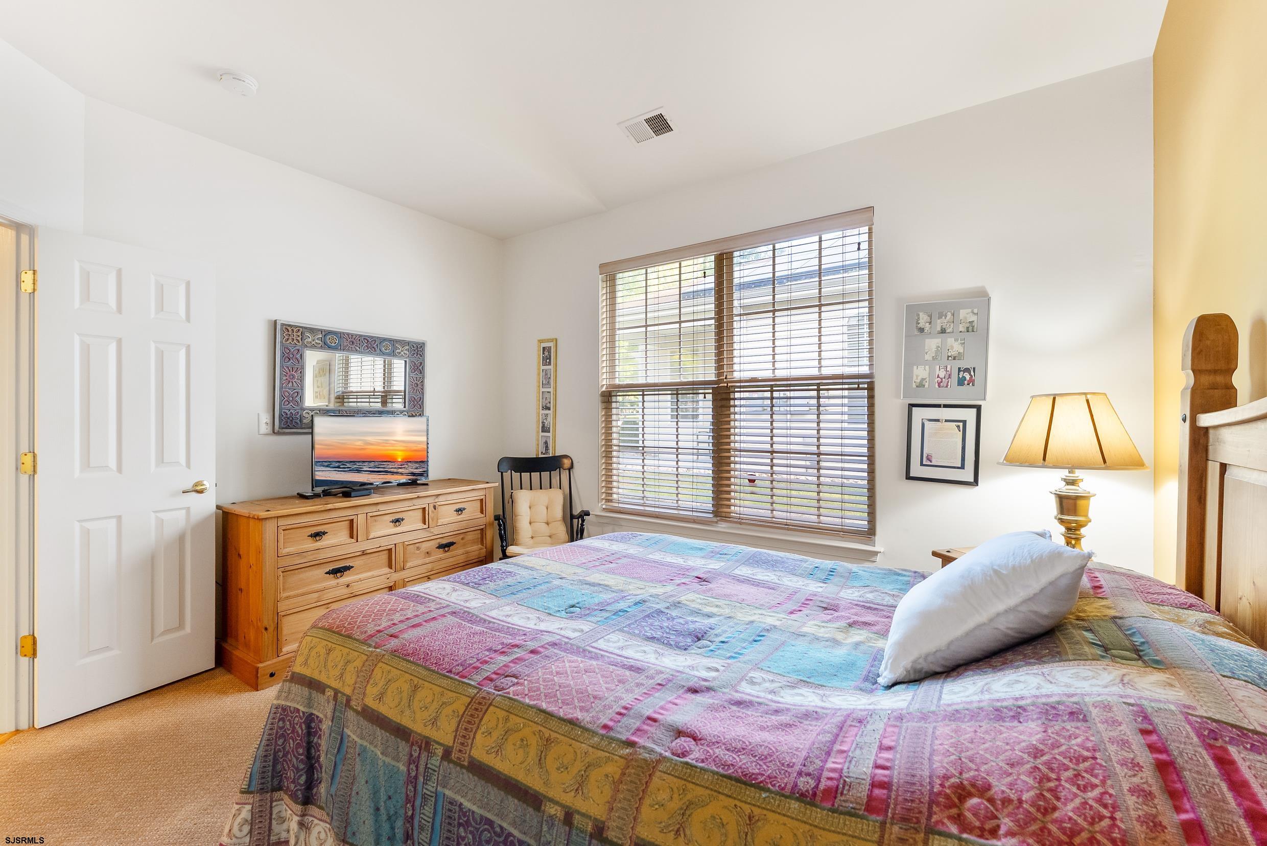 4 Northampton Road Smithville, NJ 08205 - Photo 25 of 39 a bedroom with a bed and a dresser next to a window