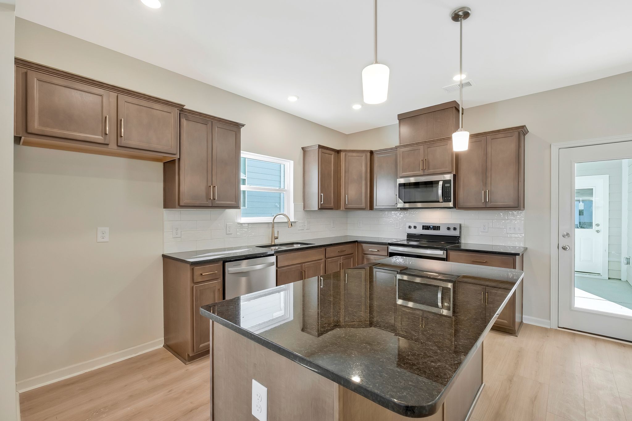 7321 Carothers Road Nolensville, TN 37135 - Photo 10 of 32 a kitchen with stainless steel appliances granite countertop a sink a stove a refrigerator cabinets and a wooden floor