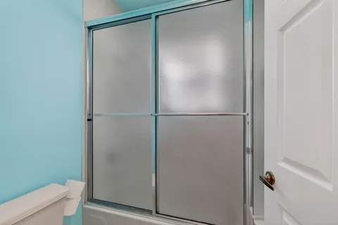 a bedroom with a bed dresser and a flat tv screen