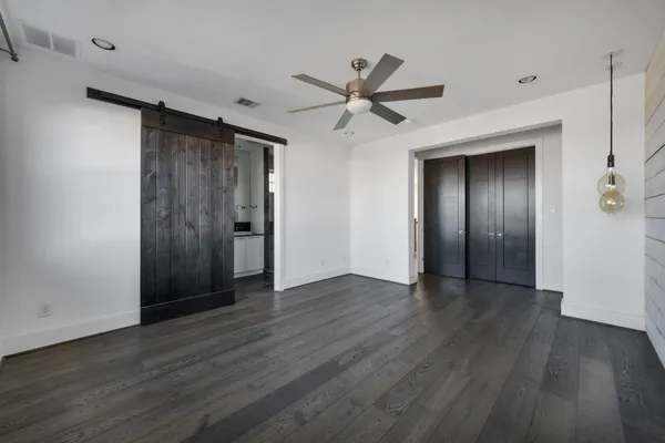 an empty room with wooden floor door and windows
