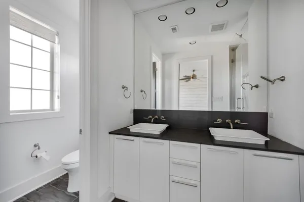 a bathroom with a double vanity sink toilet and a mirror