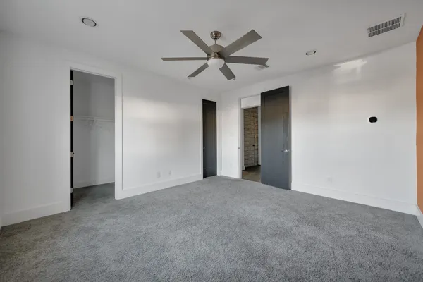 a view of an empty room with a ceiling fan