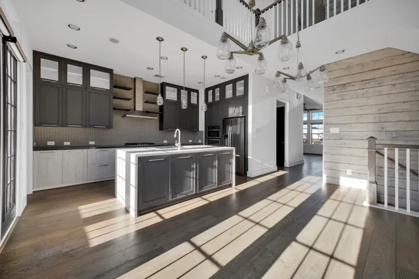 a kitchen with stainless steel appliances granite countertop a sink a stove and cabinets