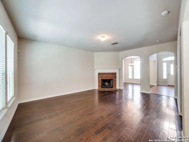 an empty room with wooden floor and fireplace